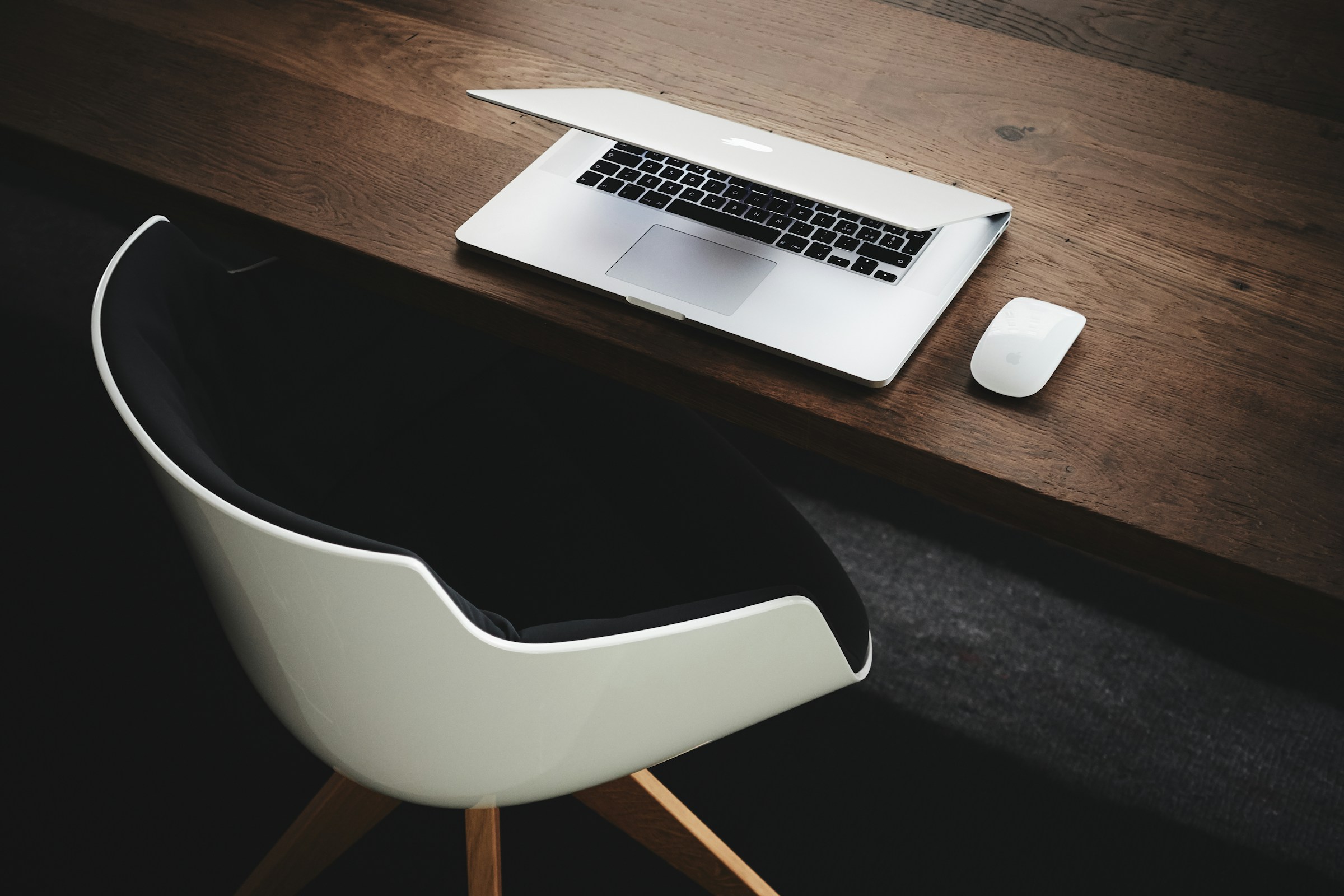 Macbook on a desk with a chair